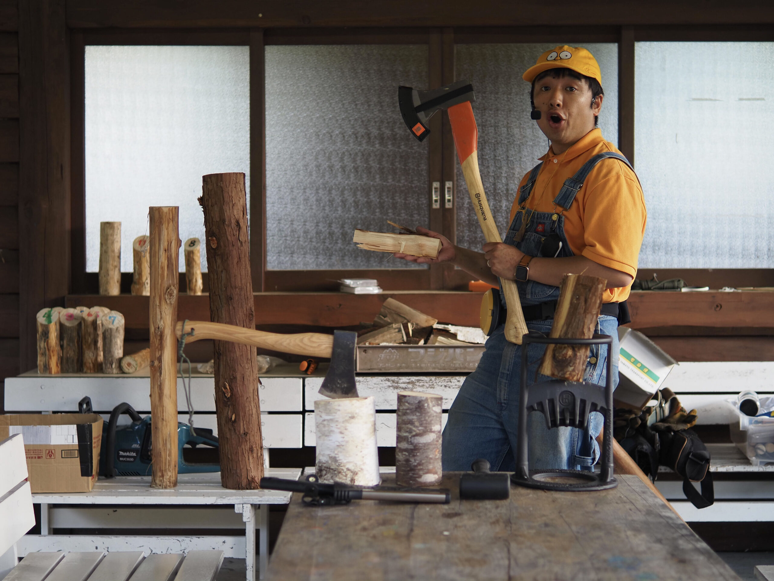 薪や斧などの道具を並べ、薪割りを説明する平野佑典さん