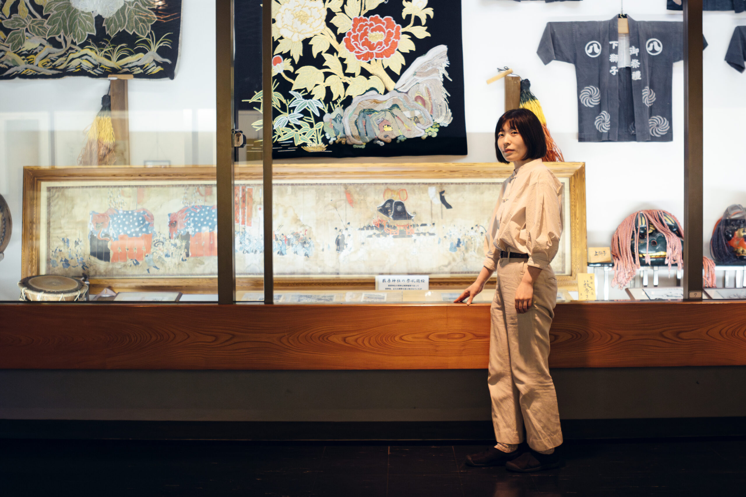郷土の祭りに関する展示の前に立つ坂口佳奈さん
